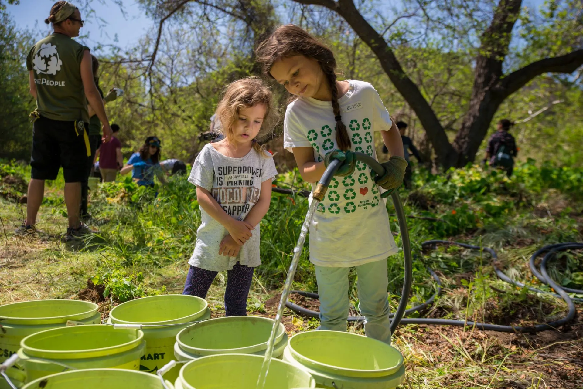 TreePeople two girls filling water buckets