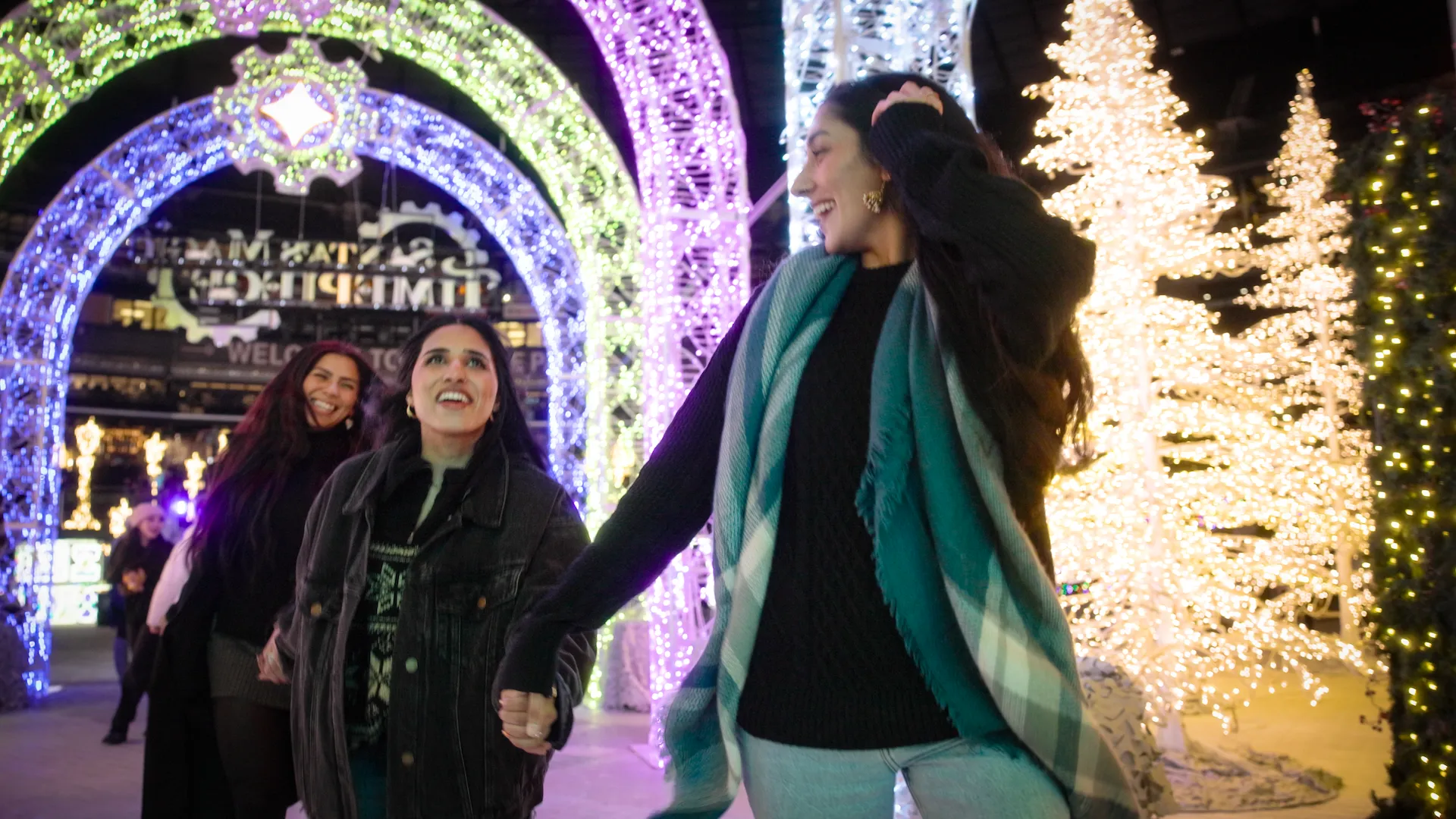 Three friends excitedly entering Enchant through the light tunnel